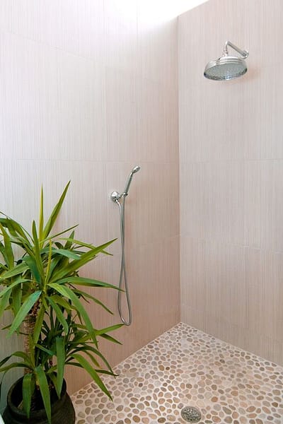 open shower master bath with walk in shower and pebble flooring