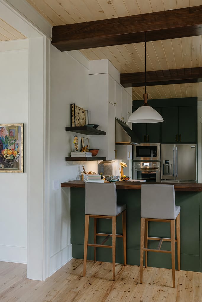 Kitchen island with upholstered counter stools, a butcher-block top and dark green cabinetry beyond