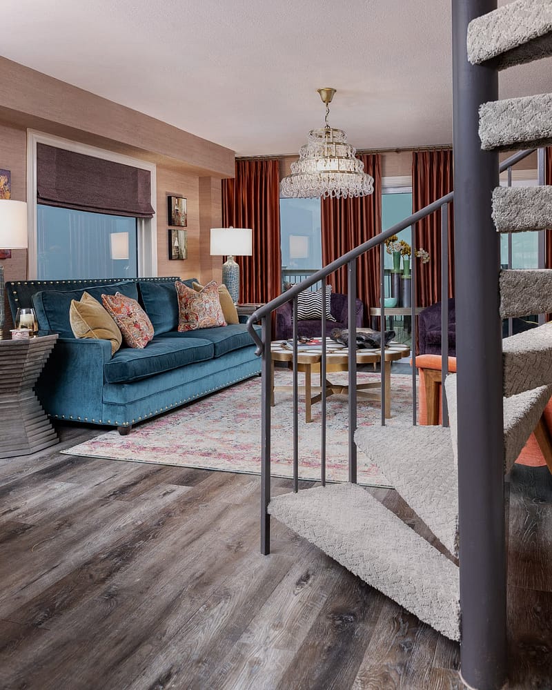 coastal condo remodel on pensacola beach living room, purple accent chairs, blue sofa, crystal chandelier, orange window treatments