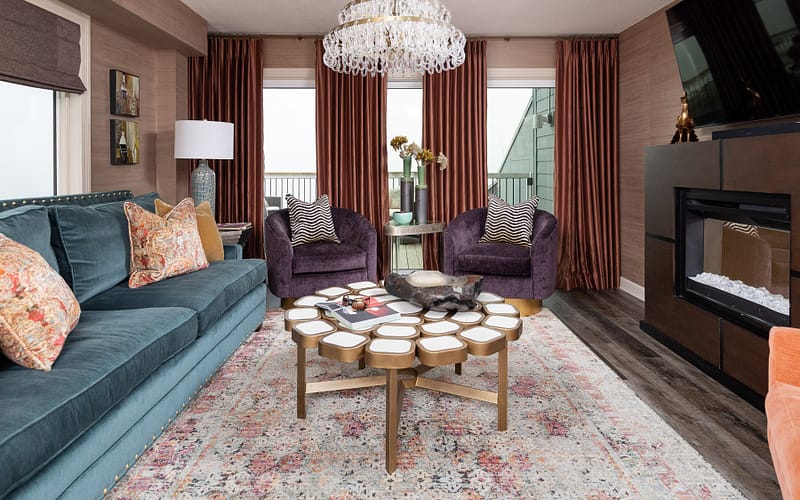 coastal condo remodel on pensacola beach living room, purple accent chairs, blue sofa, crystal chandelier, orange window treatments
