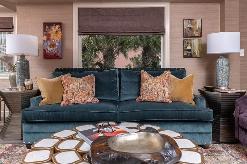 blue sofa coastal condo remodel on pensacola beach, textured grasscloth wallpaper, custom window treatments, white and brass coffee table, nailheads, blue accent lamps