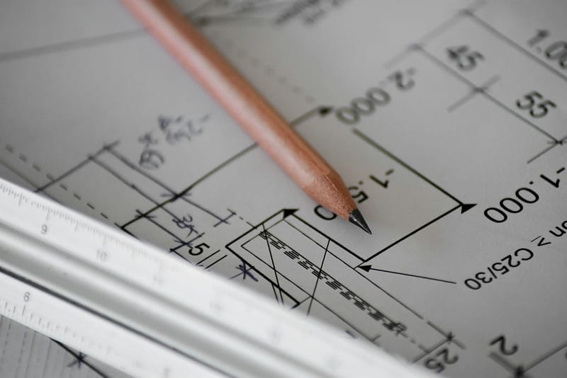 Pencil and architect's scale on a dimensioned construction drawing, the kind of plan set a Gig Harbor, WA building permit needs