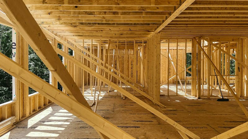 Wood framing of a new house on a wooded lot, the new-construction side of the remodel vs new construction decision in Kitsap County